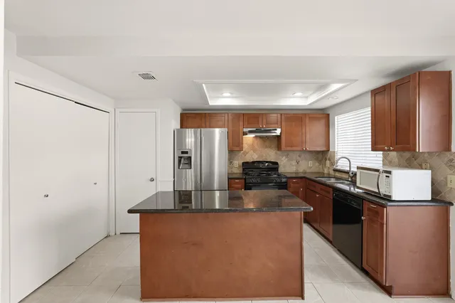 a kitchen with stainless steel appliances granite countertop a refrigerator and a stove