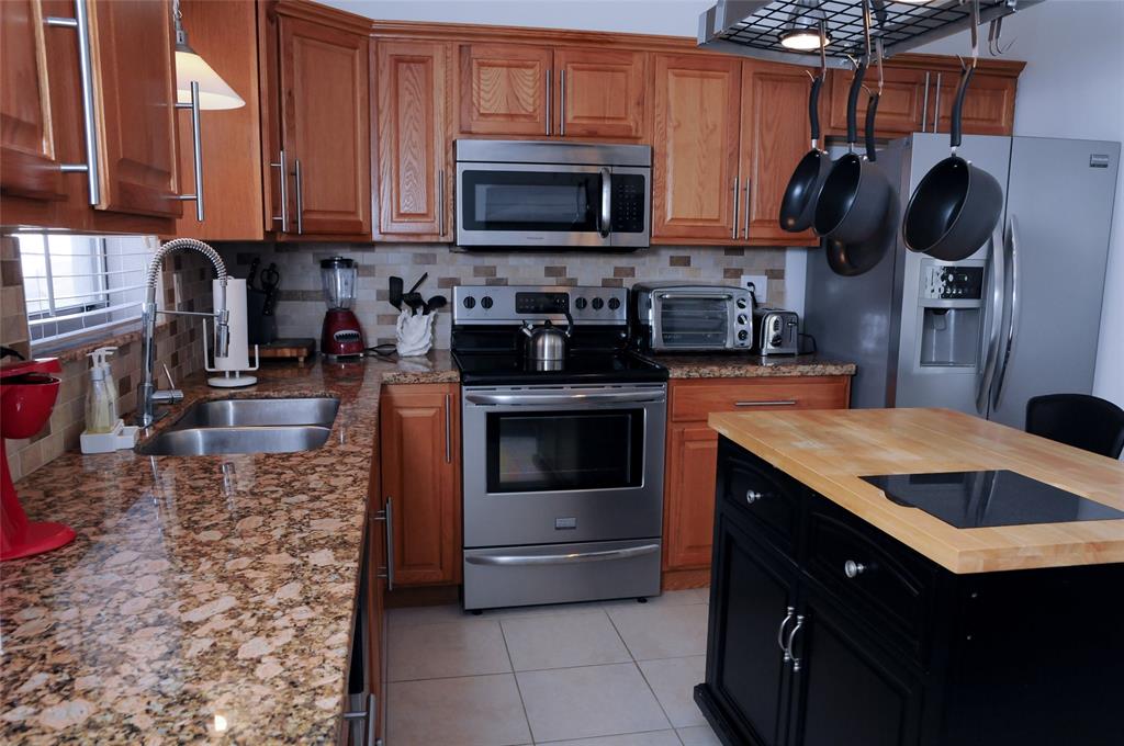29 Northeast 3rd Street Dania Beach, FL 33004 - Photo 9 of 31 a kitchen with stainless steel appliances granite countertop a stove a sink and a microwave