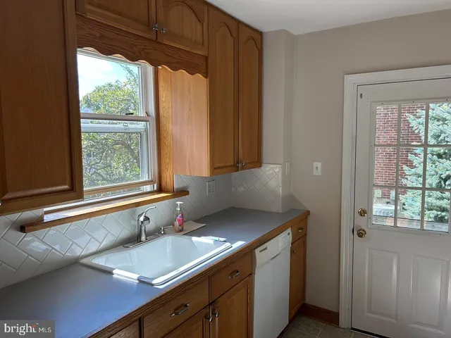 a bathroom with a granite countertop sink and a window