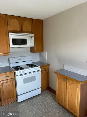 a kitchen with a stove top oven cabinets and a refrigerator