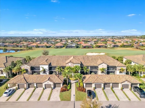 an aerial view of residential houses with outdoor space and ocean view