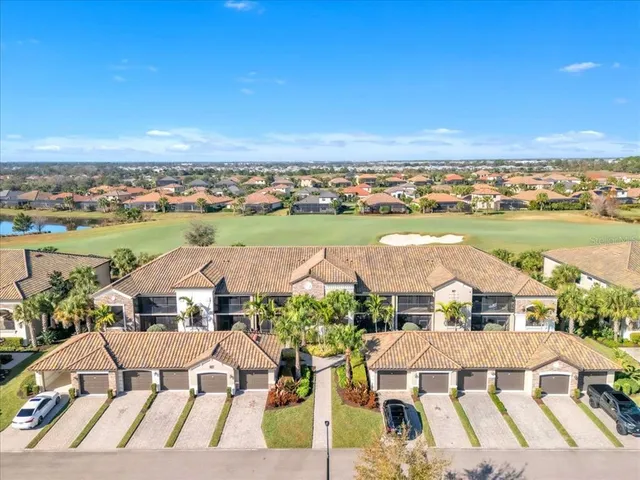 an aerial view of residential houses with outdoor space and ocean view