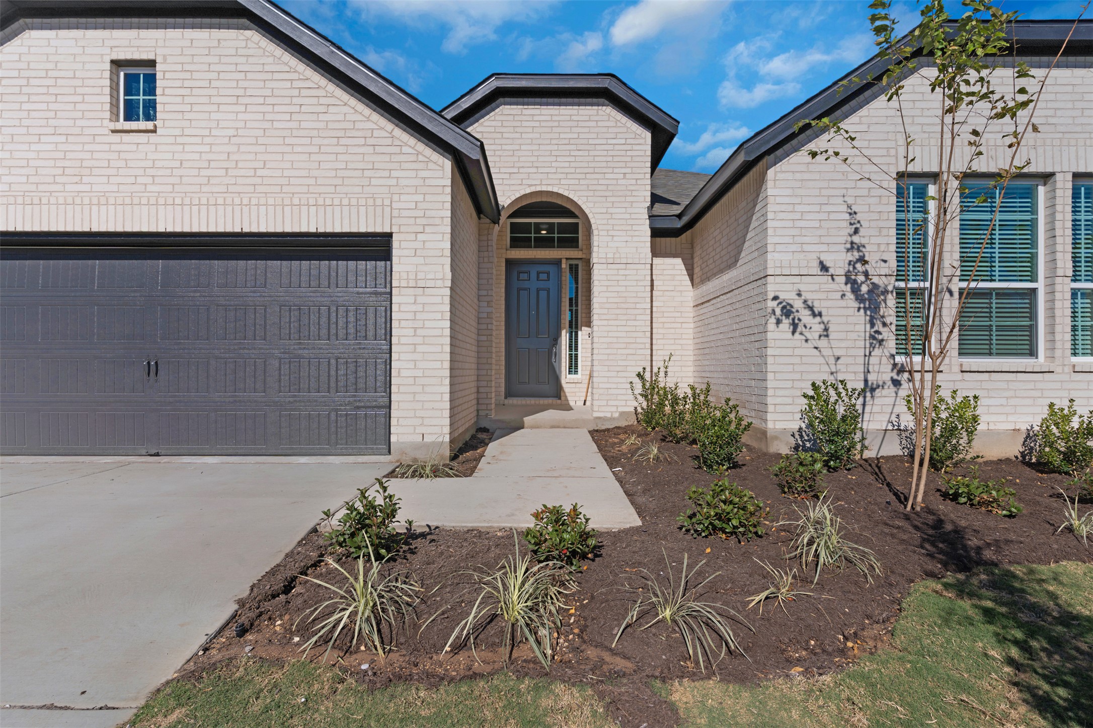 328 Ridgewell Loop Georgetown, TX 78633 - Photo 2 of 28 View of front of home featuring an attached garage, concrete driveway, and brick siding