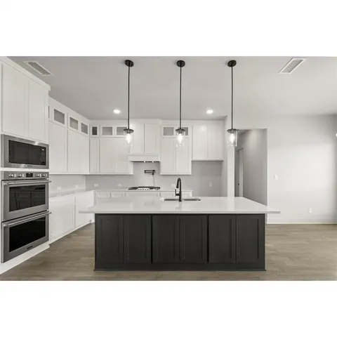 a kitchen with kitchen island cabinets and sink