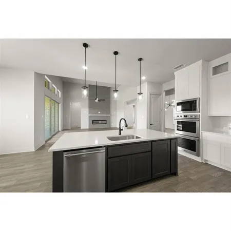 a living room with a large window and chandelier