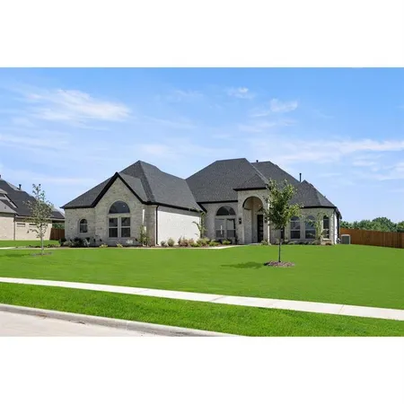 a view of a big house with a big yard and large trees