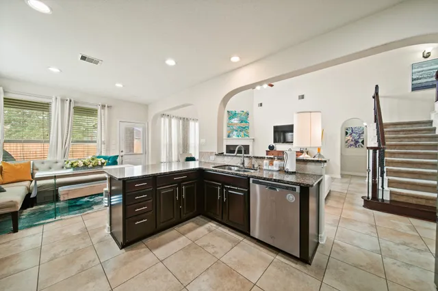 a large kitchen with kitchen island granite countertop a sink and a stove