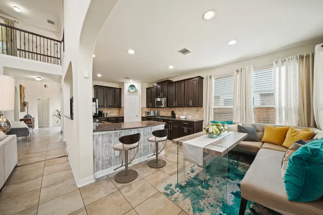 a living room with lots of furniture and a view of kitchen