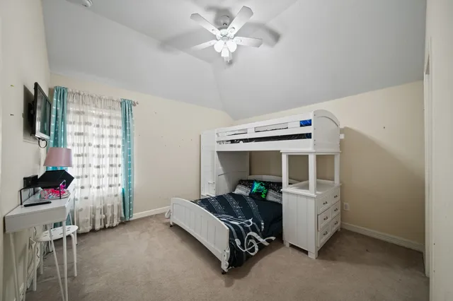 a bedroom with furniture and a fan