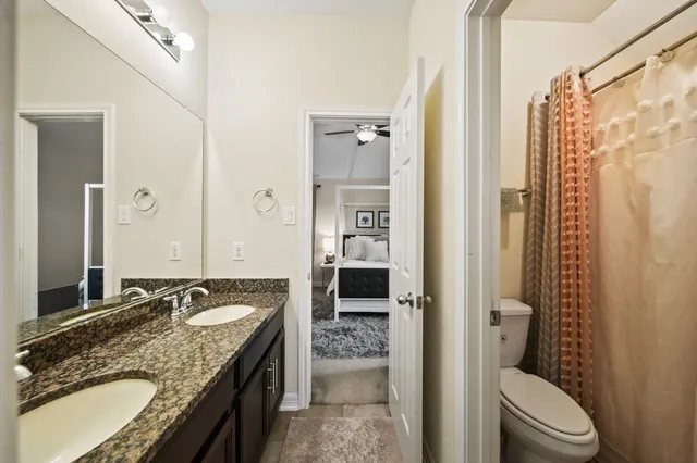 a bathroom with a granite countertop tub sink toilet and shower