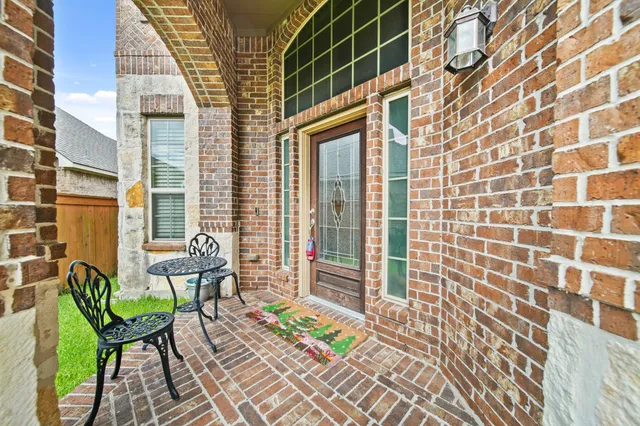 a view of a patio with a table and chairs and floor to ceiling window next to a blue wall