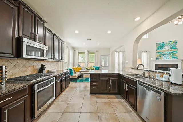 a kitchen with stainless steel appliances granite countertop a sink stove and cabinets