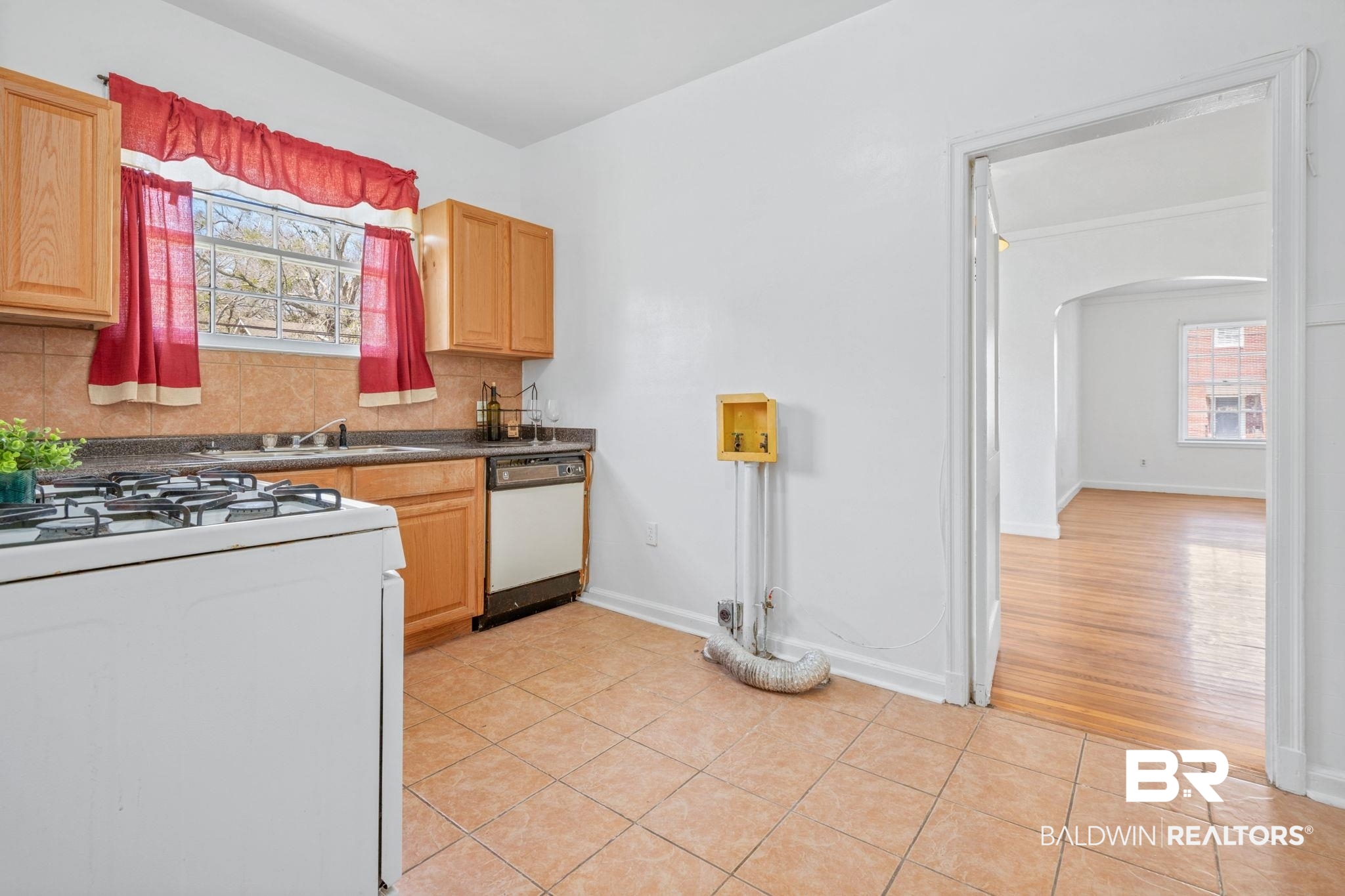 1707 Church Street Mobile, AL 36604 - Photo 8 of 43 Kitchen featuring a sink, tasteful backsplash, white appliances, arched walkways, and light tile patterned flooring