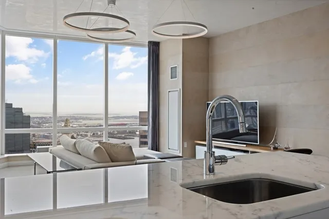 a kitchen with a sink and a view of living room