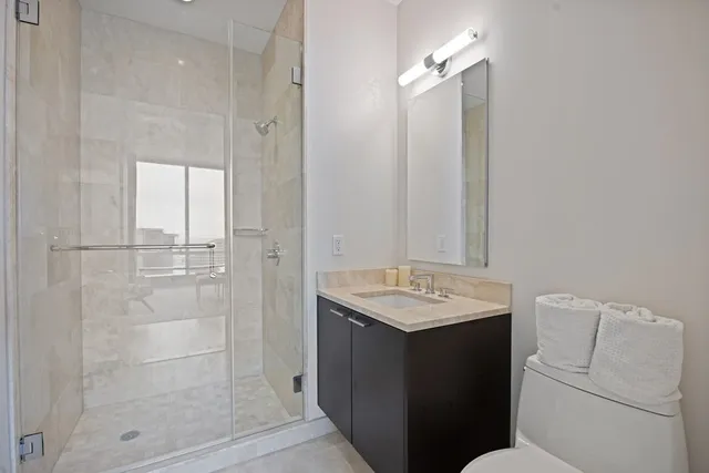 a bathroom with a sink a toilet and shower