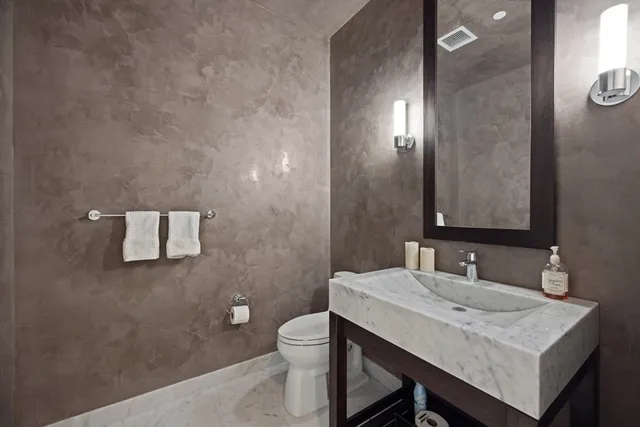 a bathroom with a sink a toilet and mirror