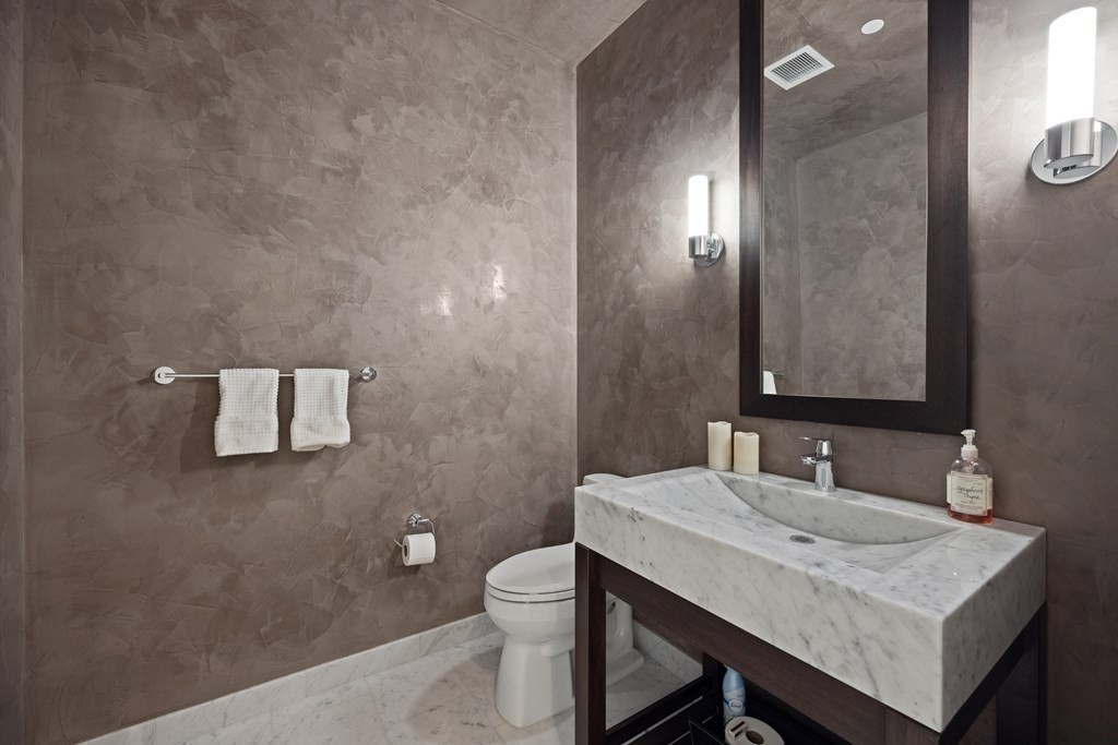 1 Franklin Street, Unit 5204 Boston, MA 02110 - Photo 17 of 40 a bathroom with a sink a toilet and mirror