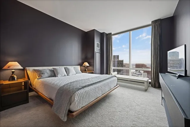 a spacious bedroom with a bed and large windows