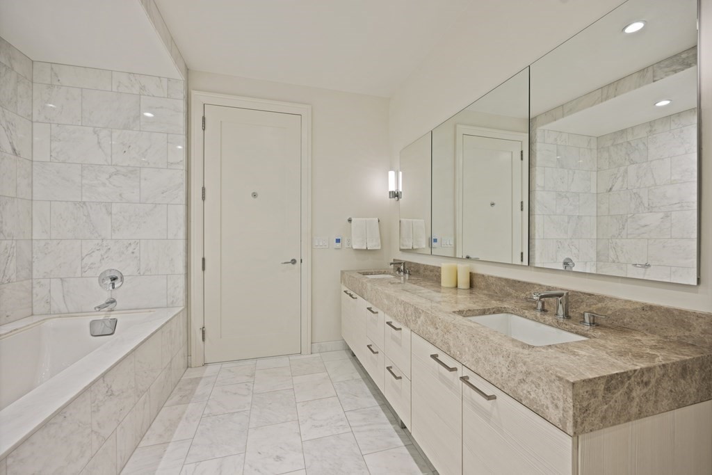 1 Franklin Street, Unit 5204 Boston, MA 02110 - Photo 22 of 40 a bathroom with a granite countertop sink mirror and a bathtub