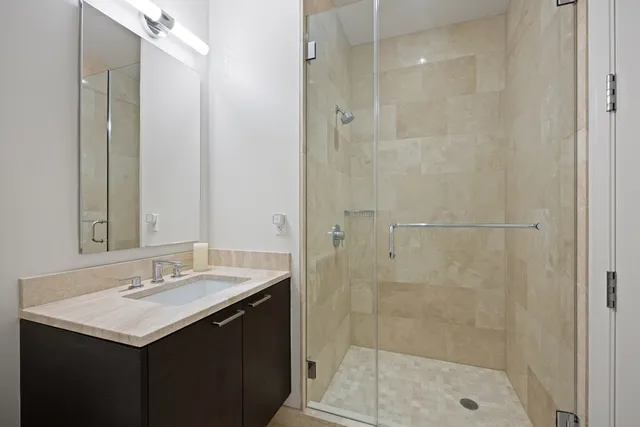 a bathroom with a sink a shower and a mirror