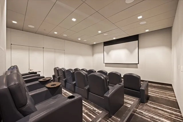 a media room with lots of chairs and a projector screen
