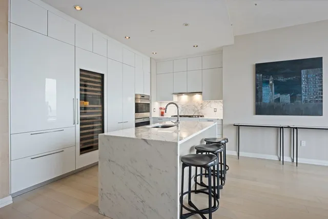 a kitchen with kitchen island a stove a refrigerator and a dining table