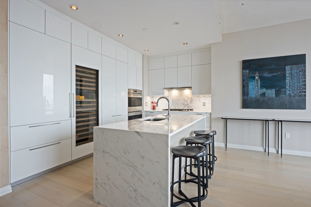 1 Franklin Street, Unit 5204 Boston, MA 02110 - Photo 10 of 40 a kitchen with kitchen island a stove a refrigerator and a dining table