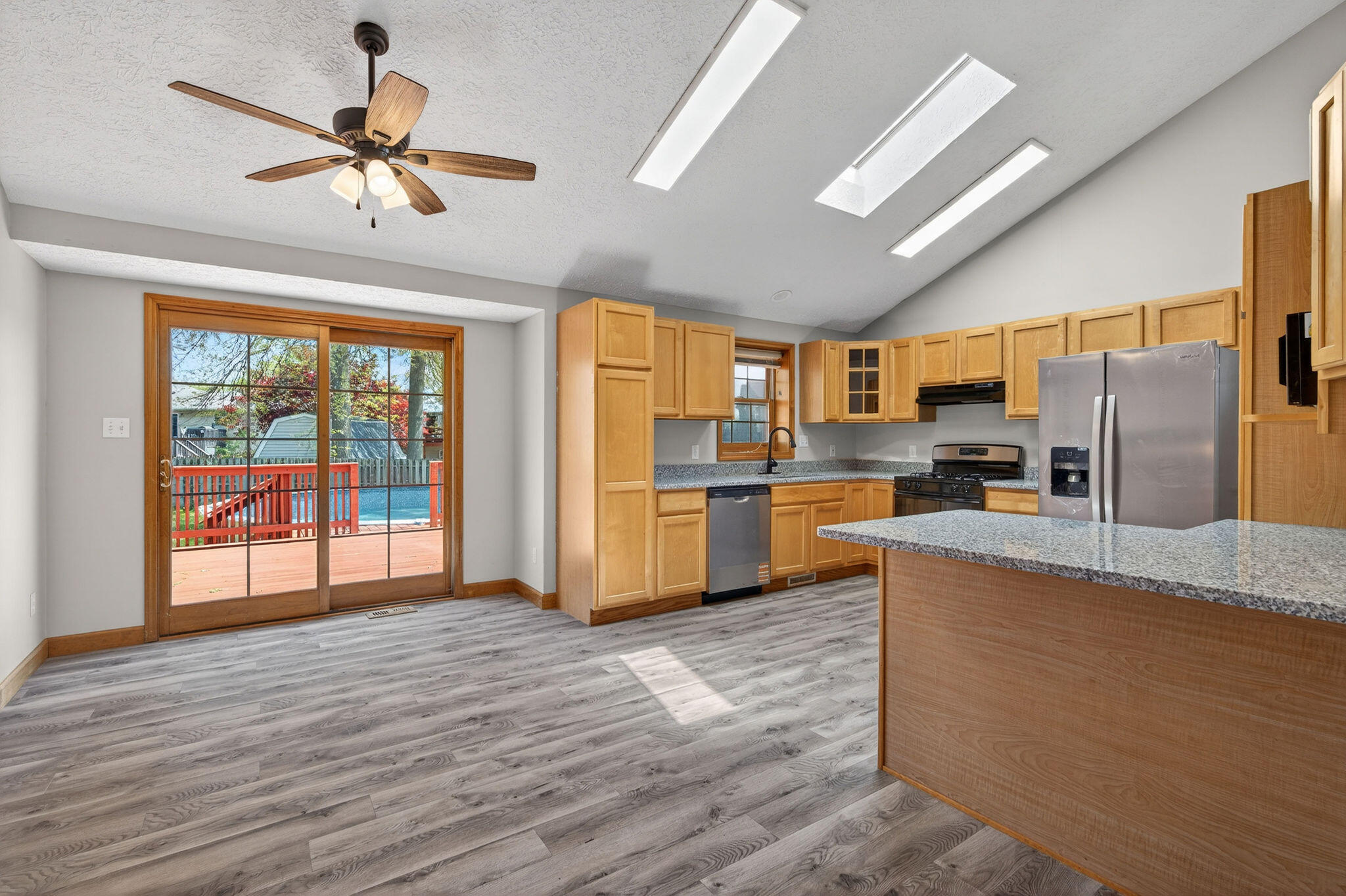 2447 Joseph Avenue Portage, IN 46368 - Photo 6 of 33 a kitchen with stainless steel appliances kitchen island granite countertop a refrigerator a stove top oven a sink with a dining table and chairs