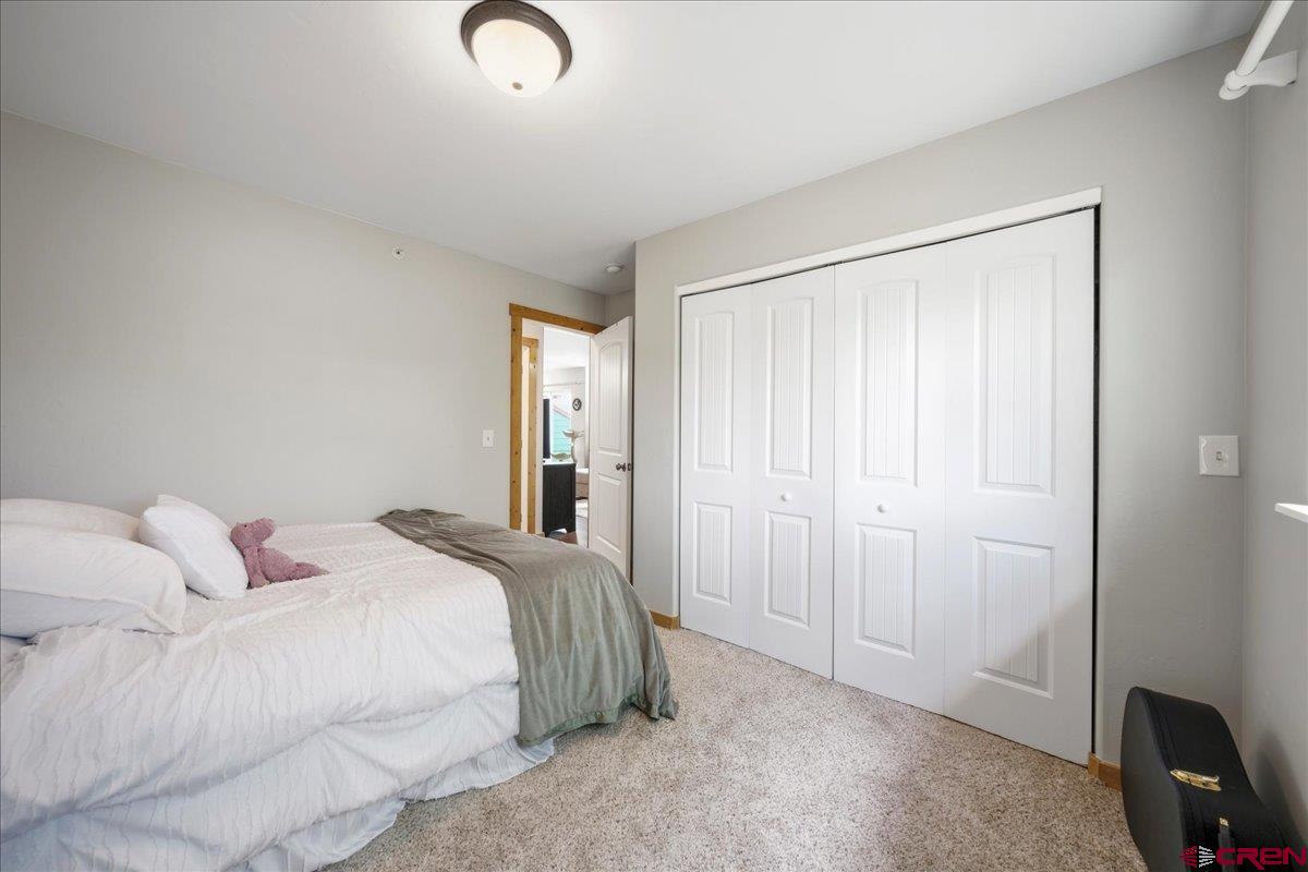 520 Redcliff Circle, Unit G203 Ridgway, CO 81432 - Photo 13 of 25 a bedroom with a bed and with a bathroom