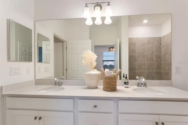 a bathroom with a granite countertop sink a mirror and shower