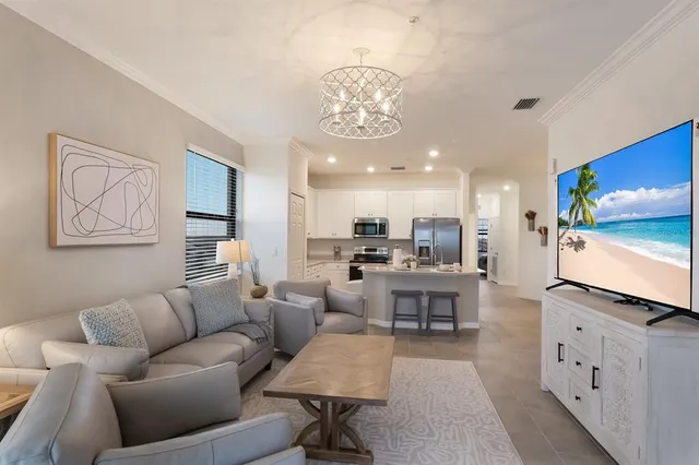 a living room with furniture kitchen view and a large mirror