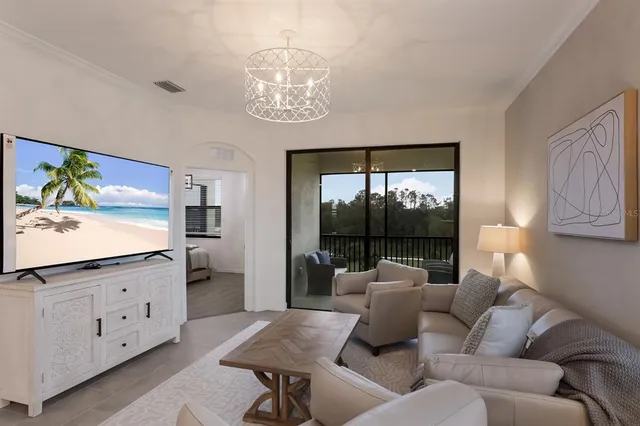 a living room with furniture a chandelier and a flat screen tv