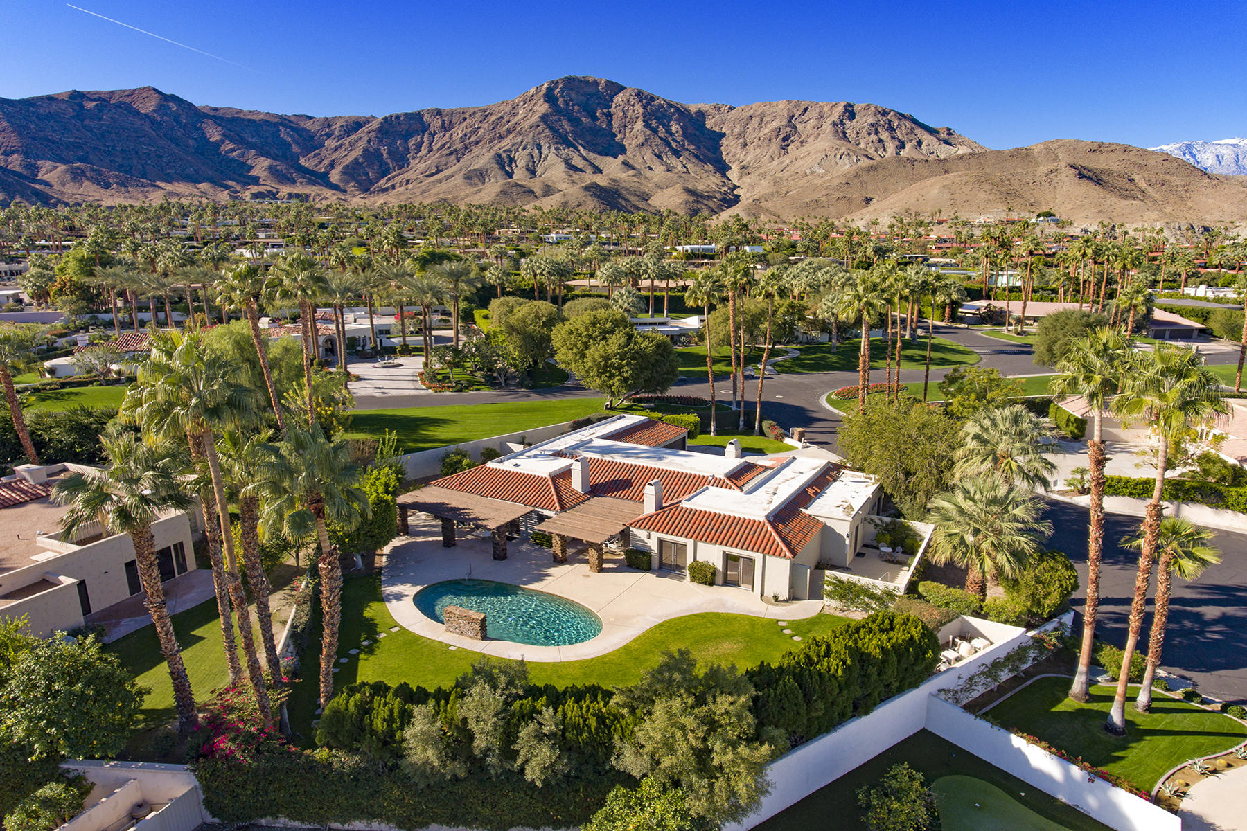 4 Boothill Circle Rancho Mirage, CA 92270 - Photo 2 of 55 a aerial view of a house with a garden and lake view
