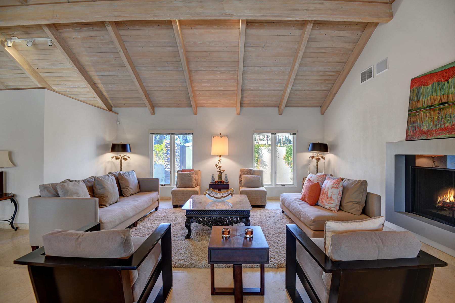 4 Boothill Circle Rancho Mirage, CA 92270 - Photo 20 of 55 a living room with furniture a fireplace and a floor to ceiling window