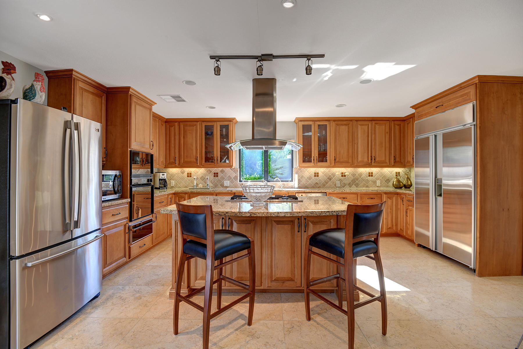 4 Boothill Circle Rancho Mirage, CA 92270 - Photo 45 of 55 a kitchen with refrigerator a sink and chairs