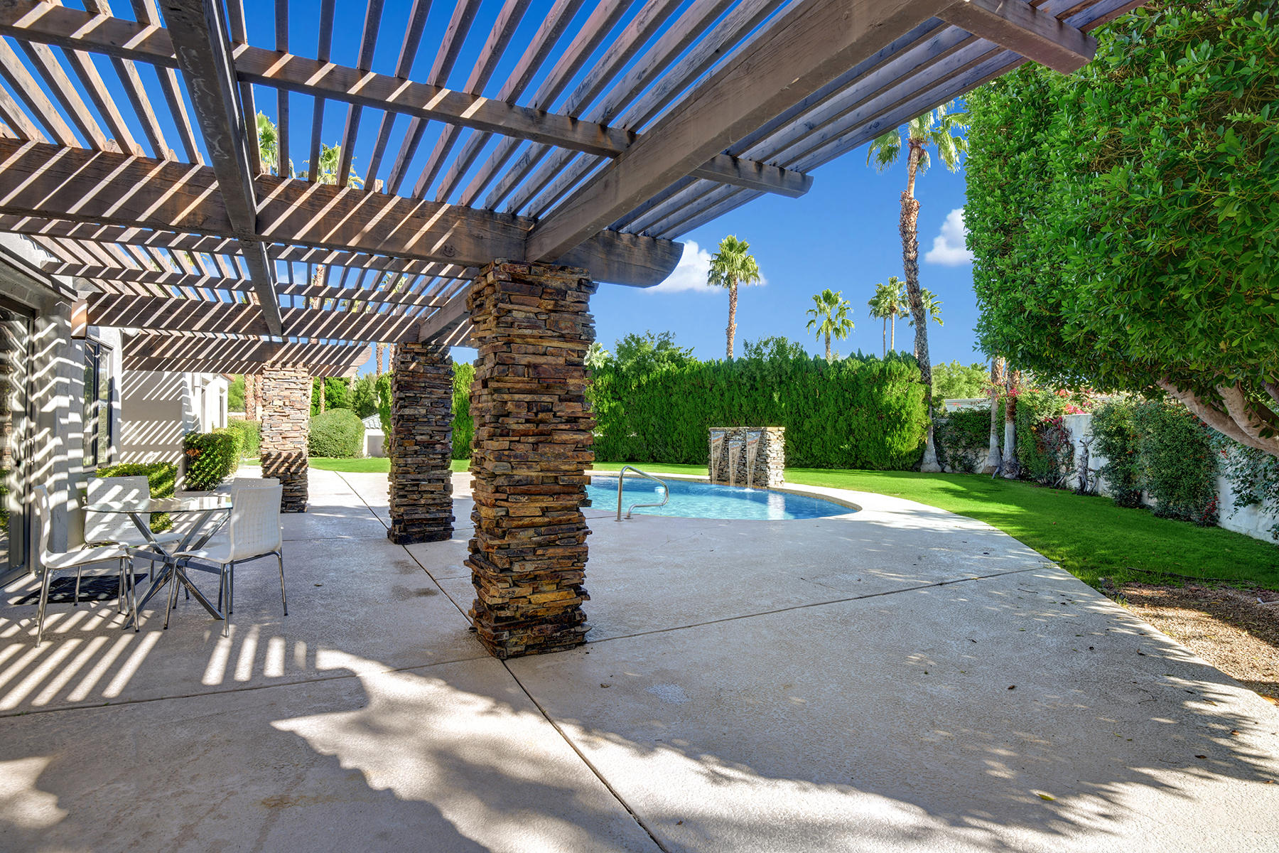4 Boothill Circle Rancho Mirage, CA 92270 - Photo 9 of 55 a patio with a table and chairs and potted plants