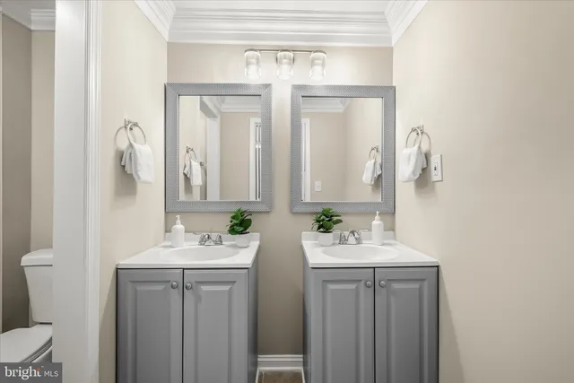 a bathroom with a double vanity sink mirror and toilet