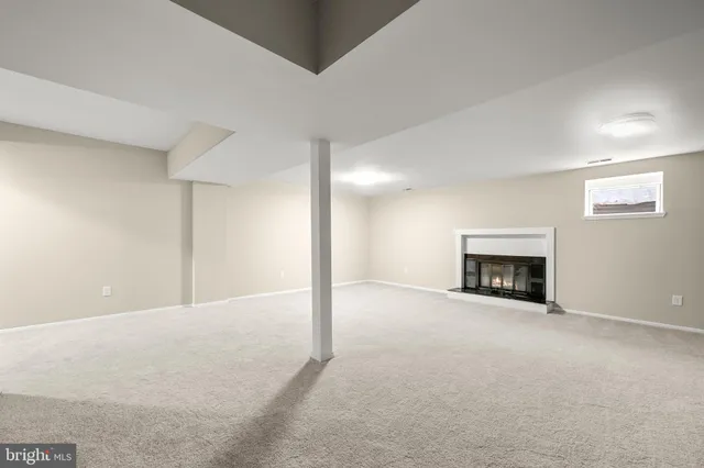 an empty room with a fireplace and a window