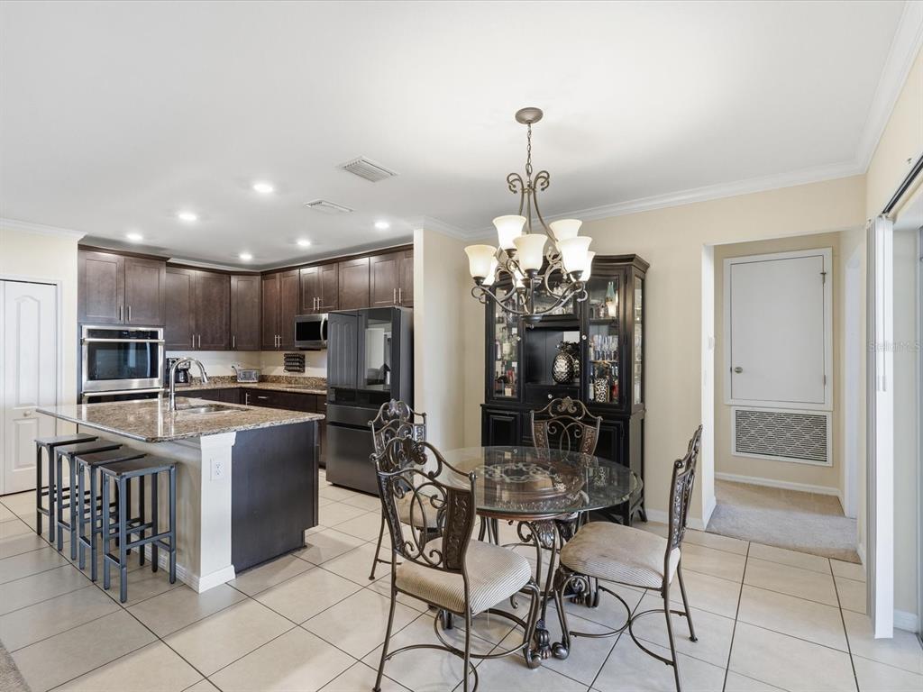 13169 Santee Street Spring Hill, FL 34609 - Photo 12 of 58 a kitchen with stainless steel appliances kitchen island granite countertop a sink and cabinets