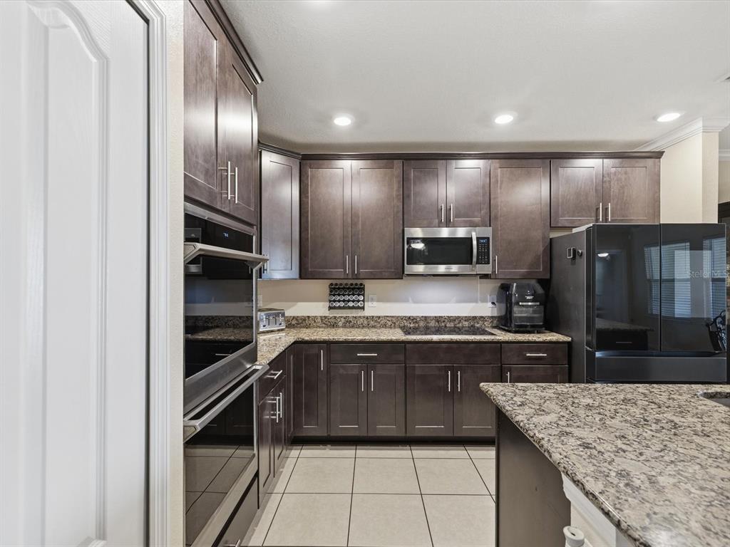 13169 Santee Street Spring Hill, FL 34609 - Photo 13 of 58 a kitchen with kitchen island granite countertop stainless steel appliances and sink