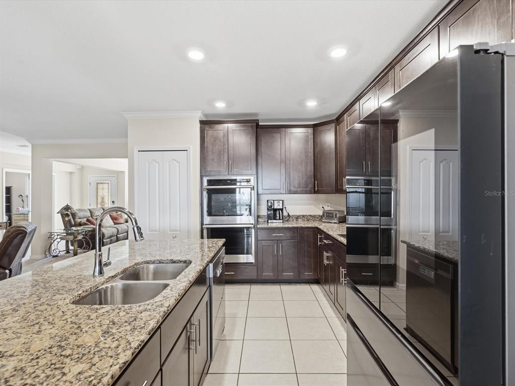 13169 Santee Street Spring Hill, FL 34609 - Photo 16 of 58 a kitchen with stainless steel appliances granite countertop a sink a stove and a refrigerator