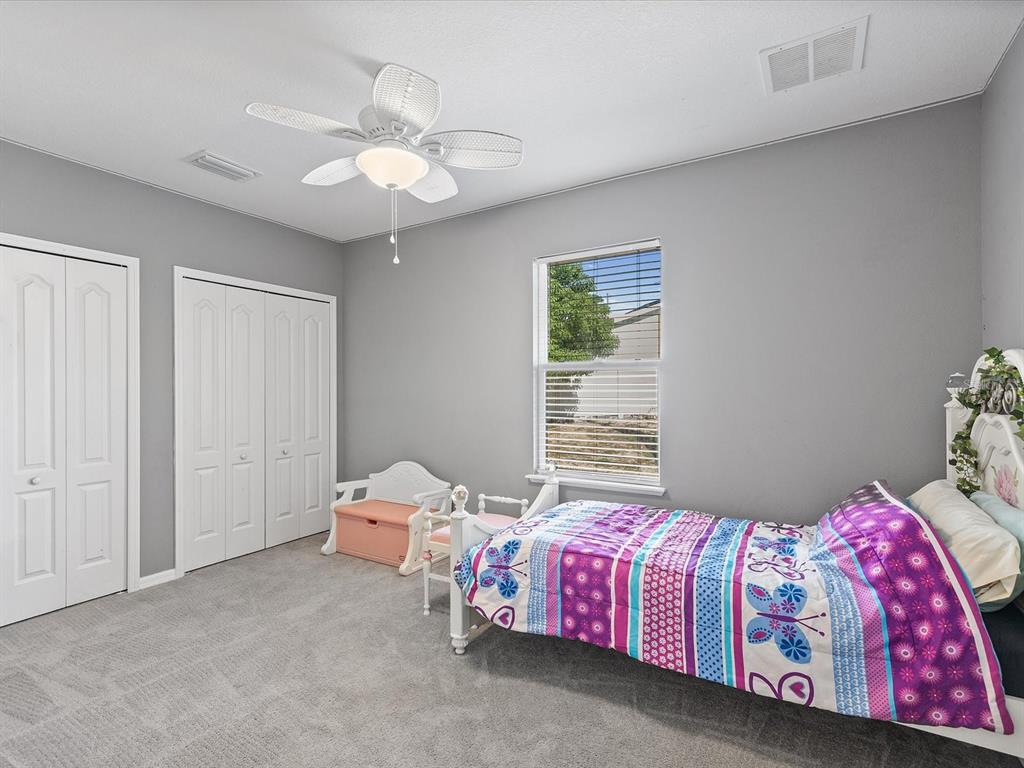 13169 Santee Street Spring Hill, FL 34609 - Photo 19 of 58 a bedroom with a bed and a chandelier