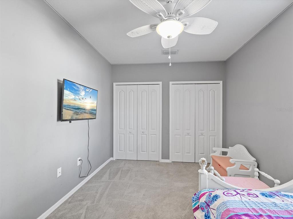 13169 Santee Street Spring Hill, FL 34609 - Photo 20 of 58 a bedroom with bed and a chandelier