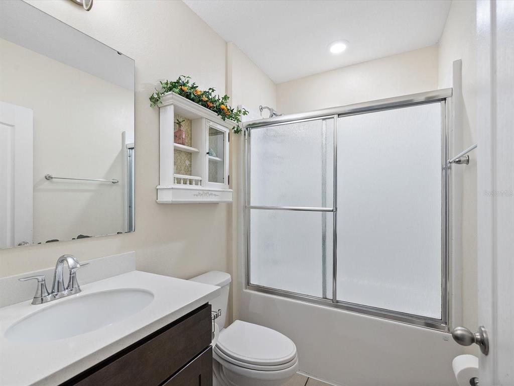 13169 Santee Street Spring Hill, FL 34609 - Photo 24 of 58 a bathroom with a sink toilet mirror and shower