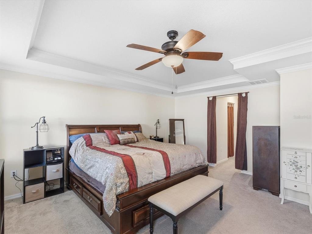 13169 Santee Street Spring Hill, FL 34609 - Photo 26 of 58 a bedroom with a bed and a chandelier