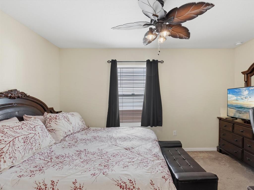 13169 Santee Street Spring Hill, FL 34609 - Photo 35 of 58 a bedroom with a bed and a chandelier