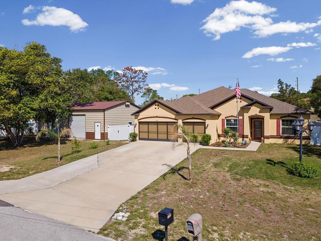 13169 Santee Street Spring Hill, FL 34609 - Photo 50 of 58 a front view of a house with a yard and garage