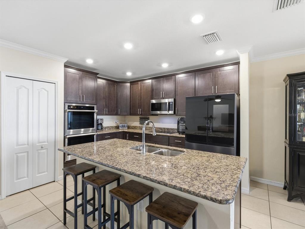 13169 Santee Street Spring Hill, FL 34609 - Photo 6 of 58 a kitchen with counter top space cabinets and stainless steel appliances