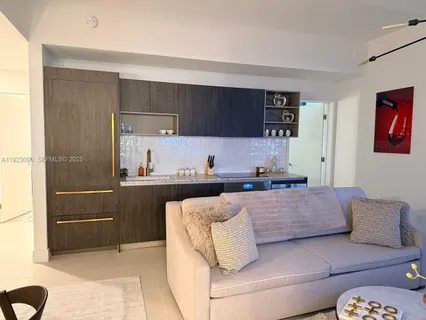 a living room with a couch and a kitchen view