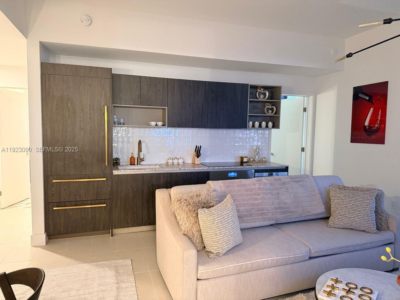 a living room with a couch and a kitchen view